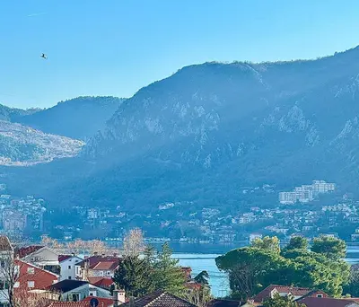 a view of a city and a lake with a mountain at Spacious two bedroom apartment with free parking in Dobrota