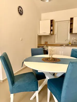 a dining room with a table and blue chairs at Spacious two bedroom apartment with free parking in Dobrota