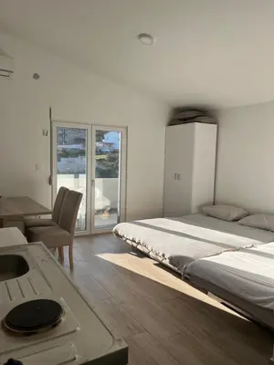a bedroom with a bed and a desk and a sink at Apartmani Dasic in Sutomore