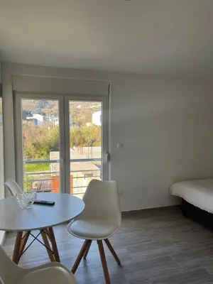 a room with a table and chairs and a bed at Apartmani Dasic in Sutomore