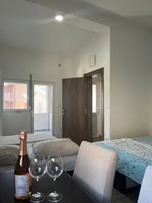 a room with a bottle of wine and two glasses on a table at Apartmani Dasic in Sutomore