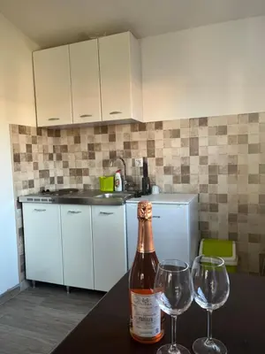 a bottle of wine sitting on a table with two wine glasses at Apartmani Dasic in Sutomore