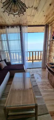 a living room with a table and a view of the ocean at Home Livari Viewpoint in Livari