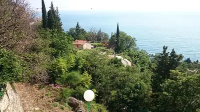 a house on a hill next to the water at PerDo in Perazića Do