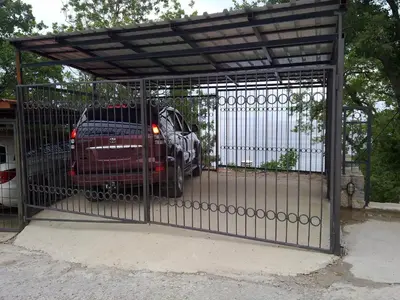 a metal gate with a car parked behind it at PerDo in Perazića Do