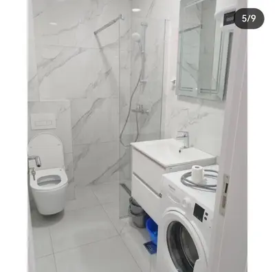 a bathroom with a toilet sink and a washing machine at Maja 12 in Podgorica