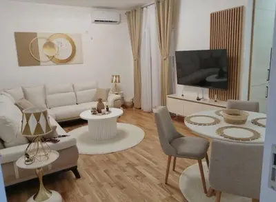 a living room with a white couch and a tv at Maja 12 in Podgorica