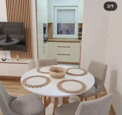 a kitchen with a table and chairs and a tv at Maja 12 in Podgorica