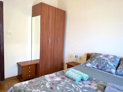 a bedroom with a bed and a wooden cabinet at Adriatic Home in Pržno