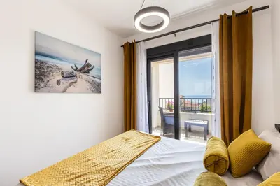 a bedroom with a bed and a view of the ocean at Apartment FORTUNELLA in Becici