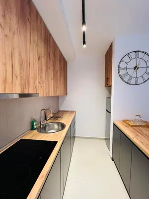 a kitchen with a sink and a clock on the wall at Apartment FORTUNELLA in Becici