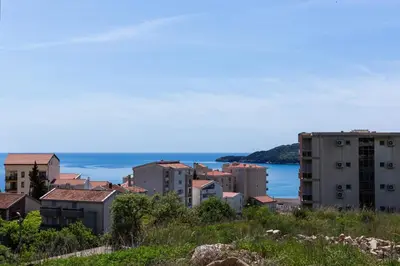 a group of buildings on a hill next to the ocean at Apartment FORTUNELLA in Becici