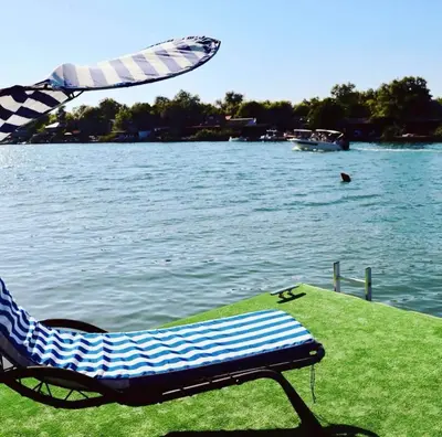 a chair sitting on the grass next to the water at Vuk - Ada Bojana in Ulcinj