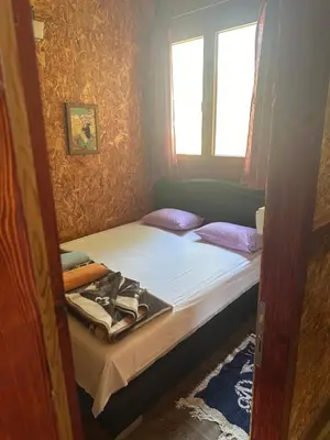 a small bedroom with a bed and a window at Vuk - Ada Bojana in Ulcinj