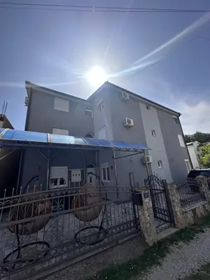 a building with a fence in front of it at Apartmani MULIC Sutomore in Sutomore
