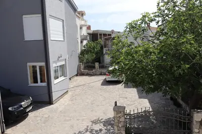 a courtyard with a car parked next to a building at Apartmani MULIC Sutomore in Sutomore