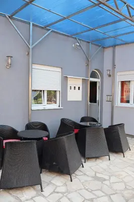 a patio with tables and chairs under a blue ceiling at Apartmani MULIC Sutomore in Sutomore