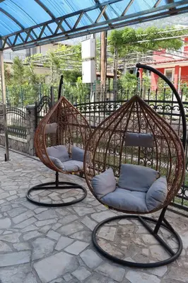 two swing chairs sitting on a stone patio at Apartmani MULIC Sutomore in Sutomore