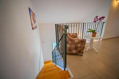 a staircase with a chair and a table in a room at Apartmani Bonaca in Tivat