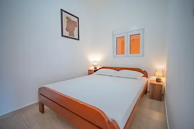 a bedroom with a large bed and two lamps at Apartmani Bonaca in Tivat
