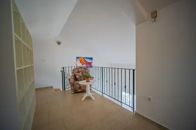 a living room with a chair and a table at Apartmani Bonaca in Tivat