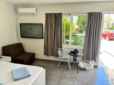 a living room with a tv and a table and a chair at Apartment Petar in Petrovac na Moru