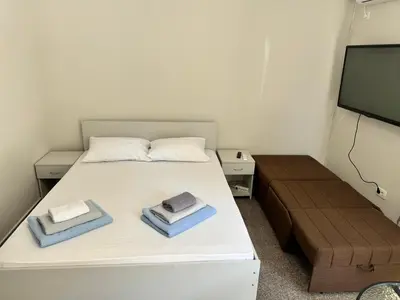 a small bedroom with a bed and a flat screen tv at Apartment Petar in Petrovac na Moru