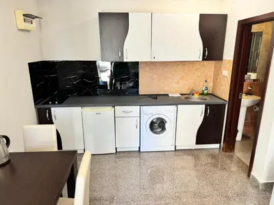 a kitchen with white cabinets and a washer and dryer at Apartment Petar in Petrovac na Moru