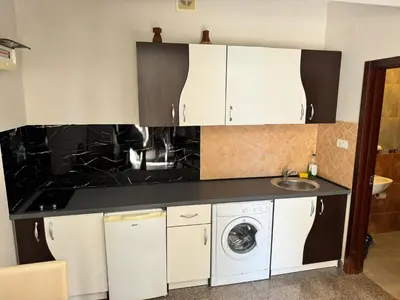 a kitchen with white cabinets and a washer and dryer at Apartment Petar in Petrovac na Moru