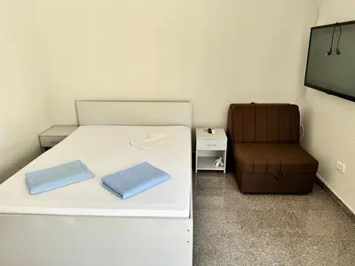 a small room with a bed and a chair at Apartment Petar in Petrovac na Moru
