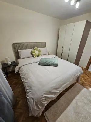 a bedroom with a large bed with a flower on it at Mimoza Apartment in Budva in Budva