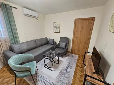 a living room with a couch and chairs and a television at Mimoza Apartment in Budva in Budva