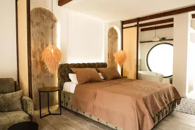 a bedroom with a bed and a chair at Datek's Apartments in Ulcinj