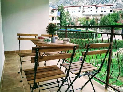 a table and chairs on a balcony with a view at Rooms & Apartments Vukasović in Kotor