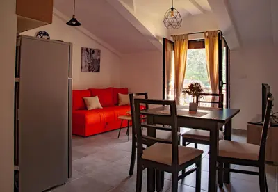 a living room with a red couch and a table at Rooms & Apartments Vukasović in Kotor