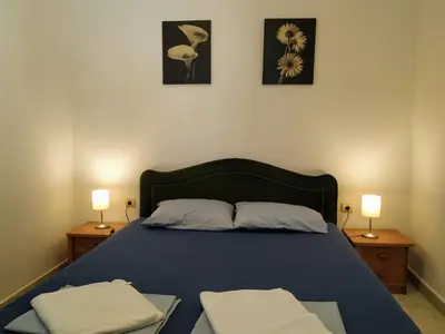 a bedroom with a blue bed with two night stands at Rooms & Apartments Vukasović in Kotor