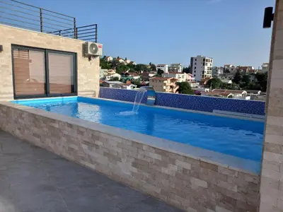 a swimming pool on the roof of a building at Apartmani Bosfor in Dobra Voda