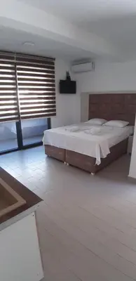 a bedroom with a large bed and a large window at Apartmani Bosfor in Dobra Voda