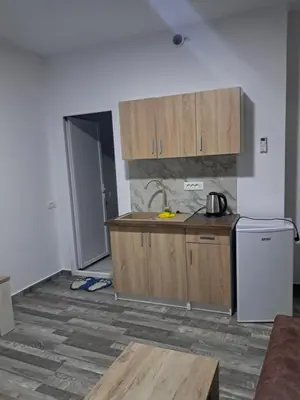 a kitchen with wooden cabinets and a counter top at Apartmani Bosfor in Dobra Voda