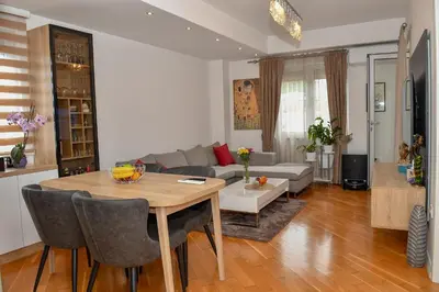 a living room with a table and a couch at Moderan dvosoban stan in Budva