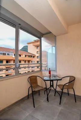 a balcony with a table and two chairs and a window at Moderan dvosoban stan in Budva