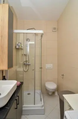 a bathroom with a shower and a toilet and a sink at Moderan dvosoban stan in Budva