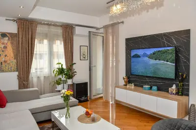 a living room with a couch and a tv at Moderan dvosoban stan in Budva