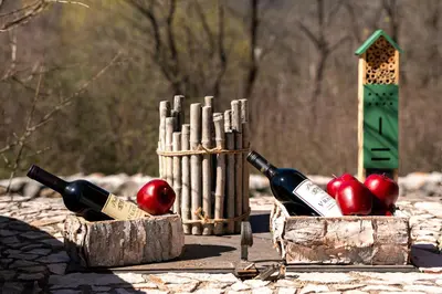 two bottles of wine and apples in wooden boxes at Handmade house Rijeka Crnojevica in Donje Selo