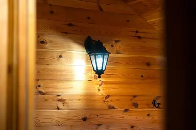 a light on a wooden wall with a lamp at Handmade house Rijeka Crnojevica in Donje Selo