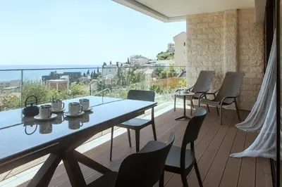 a dining room with a table and chairs on a balcony at Apartments Alacritas in Budva