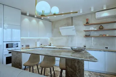 a kitchen with a marble counter top and stools at Apartments Alacritas in Budva