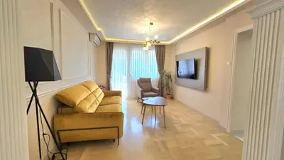 a living room with a couch and a table and a television at Luxury Suite in Kotor