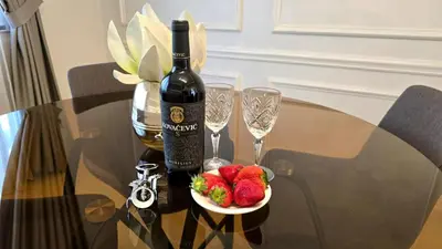 a bottle of wine and a plate of strawberries on a table at Luxury Suite in Kotor