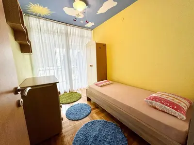 a bedroom with a bed and a window with rugs at Şehir merkezi manzaralı modern in Podgorica